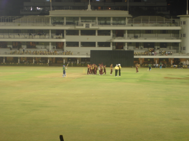 Floodlit cricket stadium during a match